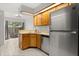 Well-lit kitchen featuring wooden cabinets, stainless steel refrigerator, and adjacent dining area at 503 Moree Loop, Winter Springs, FL 32708