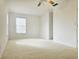 A brightly lit, carpeted bedroom featuring a ceiling fan and a window at 5421 Watervista Dr, Orlando, FL 32821