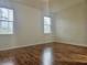 Spacious bedroom with gleaming hardwood floors and natural light from two large windows at 5421 Watervista Dr, Orlando, FL 32821