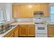 Functional kitchen featuring light wood cabinets, laminate countertops, a stove, and an open layout at 5421 Watervista Dr, Orlando, FL 32821