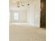 A well-lit, carpeted bedroom with a ceiling fan and a view through the window at 5421 Watervista Dr, Orlando, FL 32821