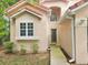 Inviting front exterior of a tan two-story home showcasing a tiled roof, window details, and a charming entrance at 5421 Watervista Dr, Orlando, FL 32821
