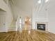 Bright living room boasts vaulted ceilings, hardwood floors, a fireplace, and stairs leading to the second floor at 5421 Watervista Dr, Orlando, FL 32821