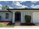 Charming home showcasing a blue front door and manicured landscaping at 7584 Lodge Pole Trl, Winter Park, FL 32792