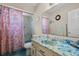 Bathroom with blue countertop and tub, toilet, sink, and pink floral shower curtain at 1132 Feather Dr, Deltona, FL 32725