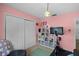 Bright bedroom with a Peloton bike, storage shelves and pink walls at 1132 Feather Dr, Deltona, FL 32725