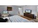 A bedroom featuring a bed, a desk, and a television on a dresser at 1132 Feather Dr, Deltona, FL 32725