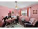 Unique bedroom featuring pink walls, modern workout equipment, an office setup and a comfortable chair at 1132 Feather Dr, Deltona, FL 32725