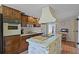Galley kitchen featuring wood cabinets, stainless steel appliances, a stone island, and an eat-in dining area at 1132 Feather Dr, Deltona, FL 32725