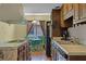 Galley kitchen featuring wood cabinets, stainless steel appliances, a stone island, and an eat-in dining area at 1132 Feather Dr, Deltona, FL 32725