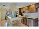 Galley kitchen featuring wood cabinets, stainless steel appliances, a stone island, and an eat-in dining area at 1132 Feather Dr, Deltona, FL 32725