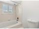 Bathroom featuring a shower-tub combination, white tile, and a window with shutters at 1532 Lawndale Cir, Winter Park, FL 32792