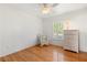 Bright bedroom with hardwood floors, a white rocking chair, and a wicker dresser at 1532 Lawndale Cir, Winter Park, FL 32792