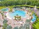 Aerial view showcasing the community pool with lounge chairs, lush landscaping and a water feature at 6137 Blue Pond Way, St Cloud, FL 34771