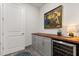 Stylish bar area with a wine refrigerator, custom cabinets, and a unique painting at 6137 Blue Pond Way, St Cloud, FL 34771