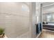 Modern bathroom with beige tiled shower, a glass wall, and gray vanity at 6137 Blue Pond Way, St Cloud, FL 34771