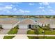 Charming single-story home with a water view, lush landscaping, and a brick-paved driveway at 6137 Blue Pond Way, St Cloud, FL 34771