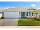 Charming single-story home with a two-car garage, brick driveway, manicured lawn and colorful landscaping at 6137 Blue Pond Way, St Cloud, FL 34771