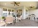 Spacious covered patio with comfortable seating, a grill, and a scenic lake view at 6137 Blue Pond Way, St Cloud, FL 34771