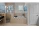 Bright bathroom featuring a soaking tub, glass-enclosed shower, and tiled floors at 972 Bighorn St, Oviedo, FL 32765