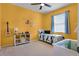 Cheerful bedroom with bright yellow walls, whimsical wall decals, and a comfortable single bed at 972 Bighorn St, Oviedo, FL 32765