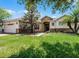 Landscaped front yard with a well-maintained lawn and mature trees, enhancing the home's exterior appeal at 972 Bighorn St, Oviedo, FL 32765