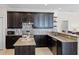 Modern kitchen featuring granite countertops, tile backsplash, stainless steel appliances, and dark cabinetry at 972 Bighorn St, Oviedo, FL 32765