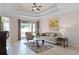 Bright living room with tray ceiling, neutral walls, tile flooring, and sliding glass door to patio at 972 Bighorn St, Oviedo, FL 32765
