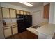 Functional kitchen with laminate flooring, black appliances, and ample cabinet space at 1075 S Hiawassee Rd # 916, Orlando, FL 32835