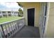 The patio has white railings, a black door, and a view of the yard and building at 1075 S Hiawassee Rd # 916, Orlando, FL 32835