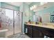 Bathroom with a dual sink vanity, a glass-enclosed shower, and blue walls, enhancing the bright interior at 1350 Royal St George Blvd, Davenport, FL 33896