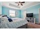 Bedroom with blue walls, a ceiling fan, and a large window offering ample natural light at 1350 Royal St George Blvd, Davenport, FL 33896
