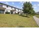 Charming townhouse with white exterior, pergola-covered patios, and lush green lawn at 1350 Royal St George Blvd, Davenport, FL 33896