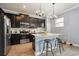 Modern kitchen featuring stainless steel appliances, dark cabinets, and a breakfast bar at 1350 Royal St George Blvd, Davenport, FL 33896