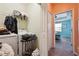 The laundry room has a washer, dryer, storage shelves, and leads to a bedroom with a blue accent wall at 1350 Royal St George Blvd, Davenport, FL 33896