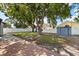 This expansive backyard features a lush lawn, mature trees, and a classic white fence for privacy at 1360 Springfield St, Kissimmee, FL 34744