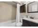 Well-lit bathroom features a shower-tub combo, dark wood vanity, and neutral tile work at 1360 Springfield St, Kissimmee, FL 34744