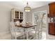 Bright dining area with a vintage hutch, white table and chairs, a modern chandelier, and glass doors to the outside at 1360 Springfield St, Kissimmee, FL 34744