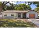 Charming single-story home with a well-maintained lawn, attached garage, and a unique stone facade on the exterior at 1360 Springfield St, Kissimmee, FL 34744