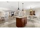 Spacious kitchen featuring an island, sleek granite countertops, rich wood cabinetry, tile floors, and an open floor plan at 1360 Springfield St, Kissimmee, FL 34744