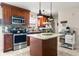 Modern kitchen with granite countertops, stainless steel appliances, dark wood cabinets, an island, and tile backsplash at 1360 Springfield St, Kissimmee, FL 34744
