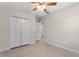 Bedroom with wood-look floors, ceiling fan with light, closet, and doorway to another room visible at 1440 Lake Shore Dr, Casselberry, FL 32707