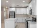 A beautifully renovated kitchen with stainless steel appliances, an island, and bright white cabinets at 1440 Lake Shore Dr, Casselberry, FL 32707