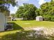 Expansive backyard with storage sheds, lush green lawn, and mature trees offering shade at 14796 Sw 39Th Cir, Ocala, FL 34473