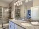 Modern bathroom features a double granite vanity, sleek lighting, and a glass-enclosed shower at 1491 Rolling Fairway Dr, Davenport, FL 33896