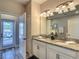 Well-lit bathroom with dual sinks, granite countertops, and modern fixtures at 1491 Rolling Fairway Dr, Davenport, FL 33896