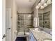 Modern bathroom features a single granite vanity, sleek lighting, and a glass-enclosed shower at 1491 Rolling Fairway Dr, Davenport, FL 33896