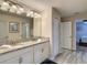 Modern bathroom features a double granite vanity, sleek lighting, and entry to bedrooms at 1491 Rolling Fairway Dr, Davenport, FL 33896