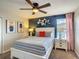 Well-lit bedroom with patterned bedding, white nightstands, and a blue accent wall at 1491 Rolling Fairway Dr, Davenport, FL 33896