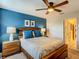 Stylish bedroom with a blue accent wall, wood bed frame, and two bedside lamps at 1491 Rolling Fairway Dr, Davenport, FL 33896